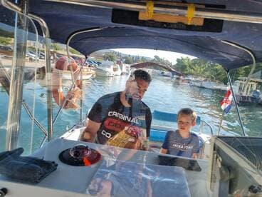 A father and son enjoy time together at the helm of a boat, showcasing a cozy cabin atmosphere perfect for family outings on the water.