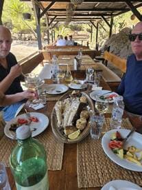 A delicious seafood feast is served at a dining area, featuring grilled fish and fresh salads, perfect for enjoying after a day on the water.