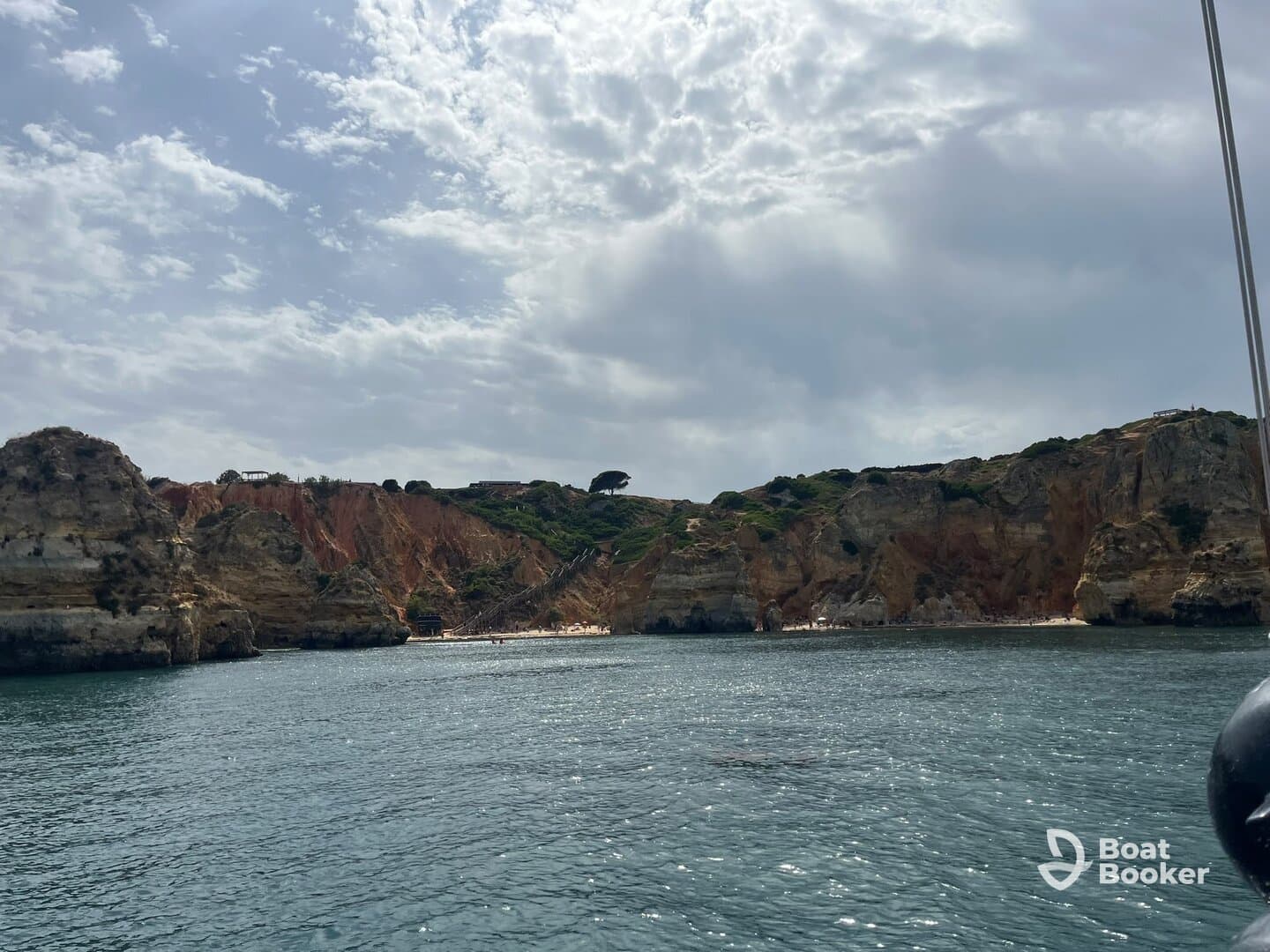 A stunning view of rugged cliffs and a sandy beach, showcasing the natural beauty of the coastline — perfect for scenic boat tours.