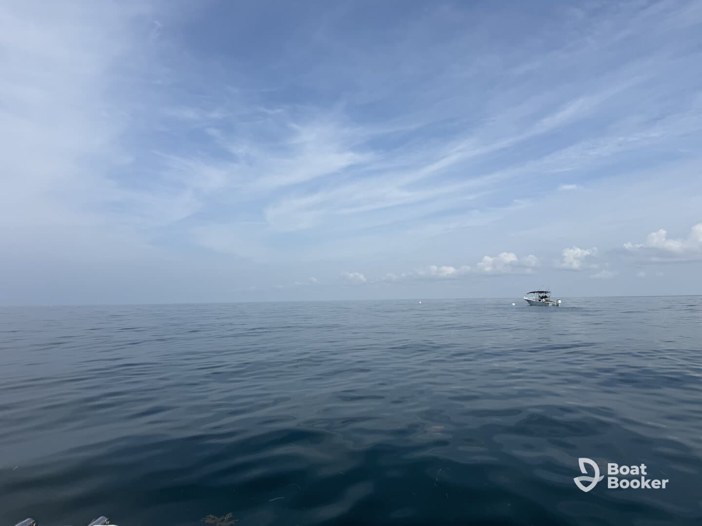 A serene view of a boat cruising on calm waters under a clear sky, perfect for showcasing peaceful boating experiences.