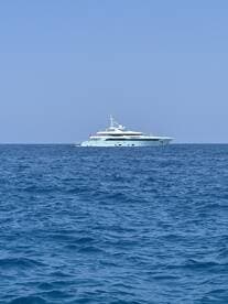A stunning yacht navigates through deep blue waters, showcasing its elegant design and luxurious appeal — perfect for upscale cruising experiences.