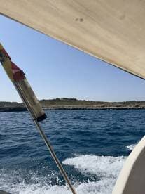 A scenic view from a boat showcasing the coastline and clear blue waters, perfect for capturing the beauty of a day on the water.