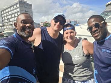 A cheerful group of friends poses for a selfie on a boat, capturing the joy of their maritime adventure together.