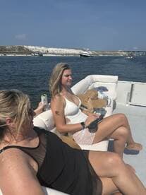 Two women relax on a boat, enjoying drinks and the sun — a perfect moment for a fun day on the water.