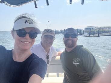 A cheerful group enjoys a day on the water, capturing a fun moment aboard a boat with smiles all around.