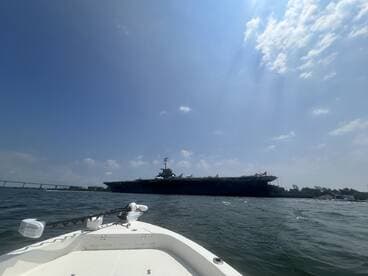 A scenic view of a military ship from a boat, showcasing the beauty of maritime experiences and the thrill of exploring the waters.
