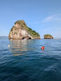 A stunning view of rocky islands rising from the clear blue waters, showcasing the natural beauty of the coastline — perfect for scenic boat tours and exploration.