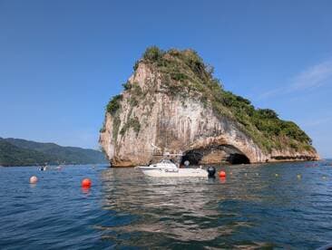 A scenic view of a boat near a stunning coastal rock formation, showcasing the beauty of the landscape and inviting exploration in the water.
