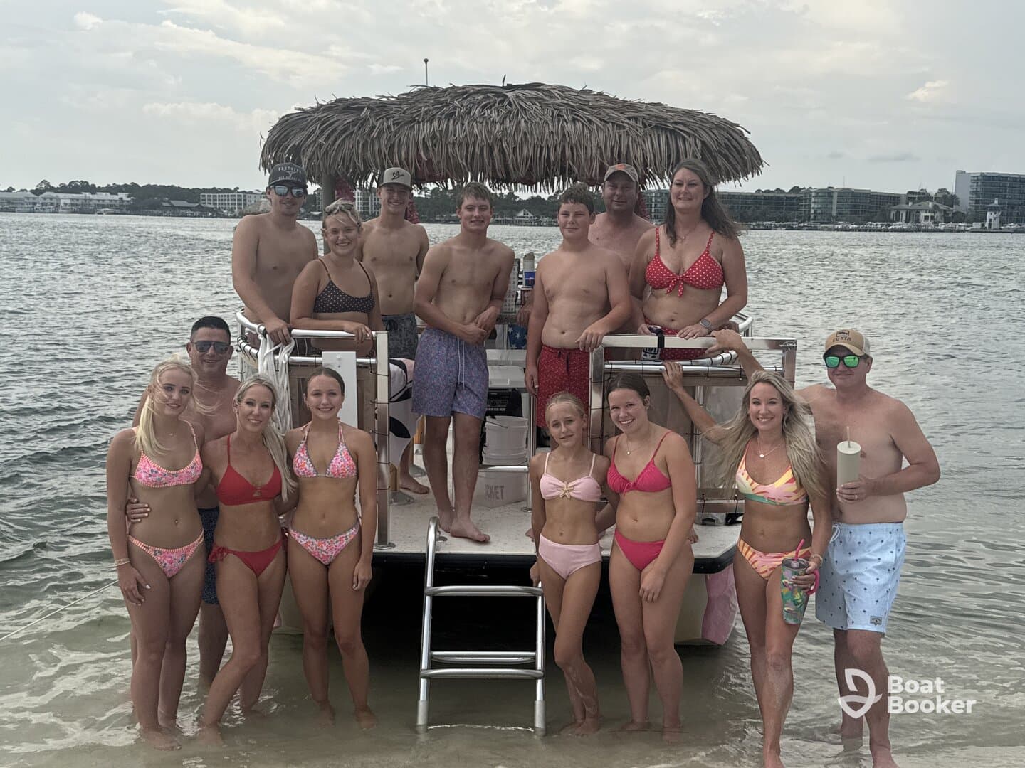 A lively group of friends poses on a pontoon boat, enjoying a fun day in the water — perfect for summer celebrations and beach outings.