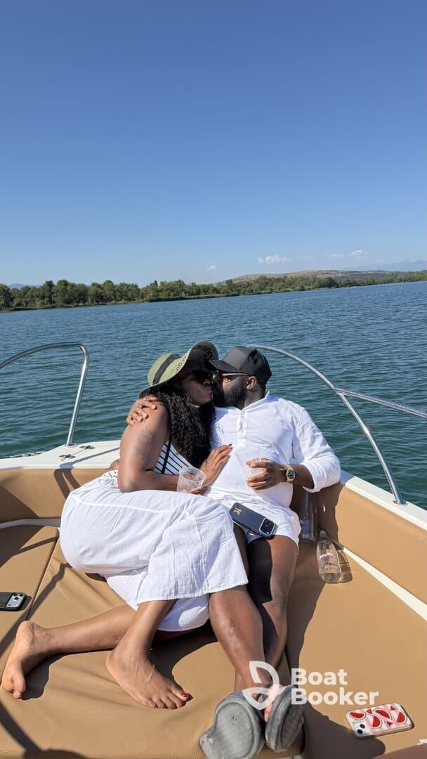 A couple shares a romantic moment on a boat, enjoying drinks and each other's company under the sun — perfect for intimate getaways or special celebrations.