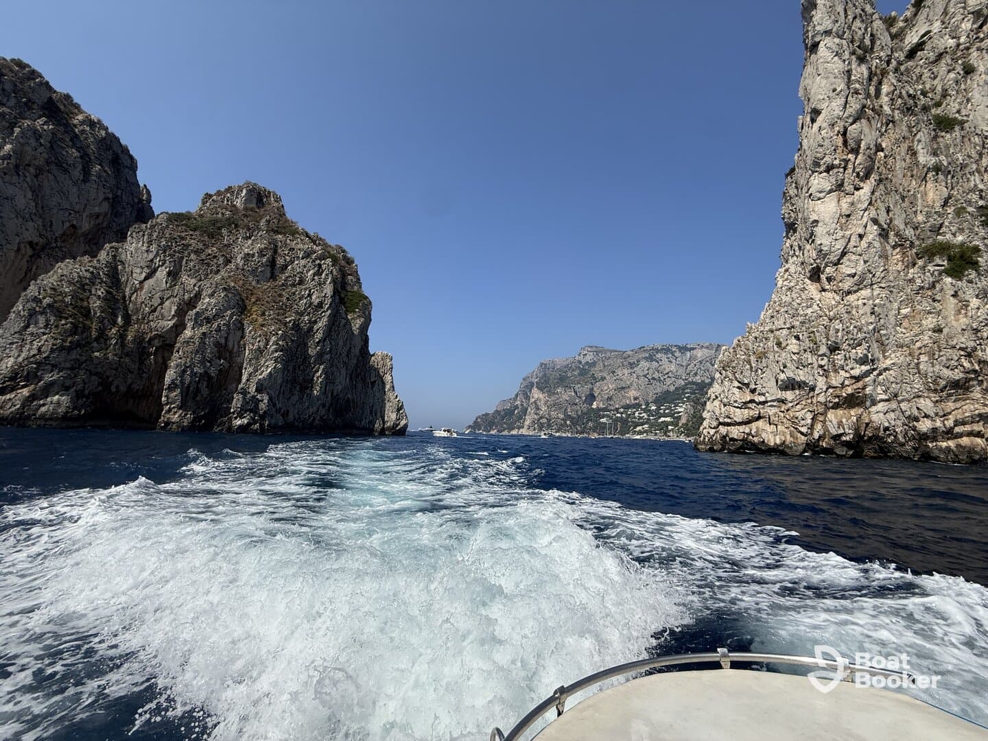 A stunning view of rocky cliffs and coastline as seen from a boat, showcasing the beauty of the landscape while cruising through the water.
