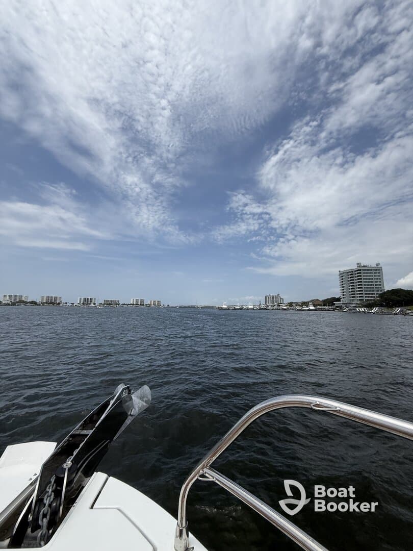 A scenic view from the bow of a boat, showcasing the calm waters and distant skyline, perfect for a relaxing day on the water.