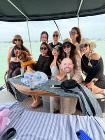 A lively group of friends enjoys a fun day on the boat, complete with a friendly dog, showcasing the perfect atmosphere for a memorable outing on the water.