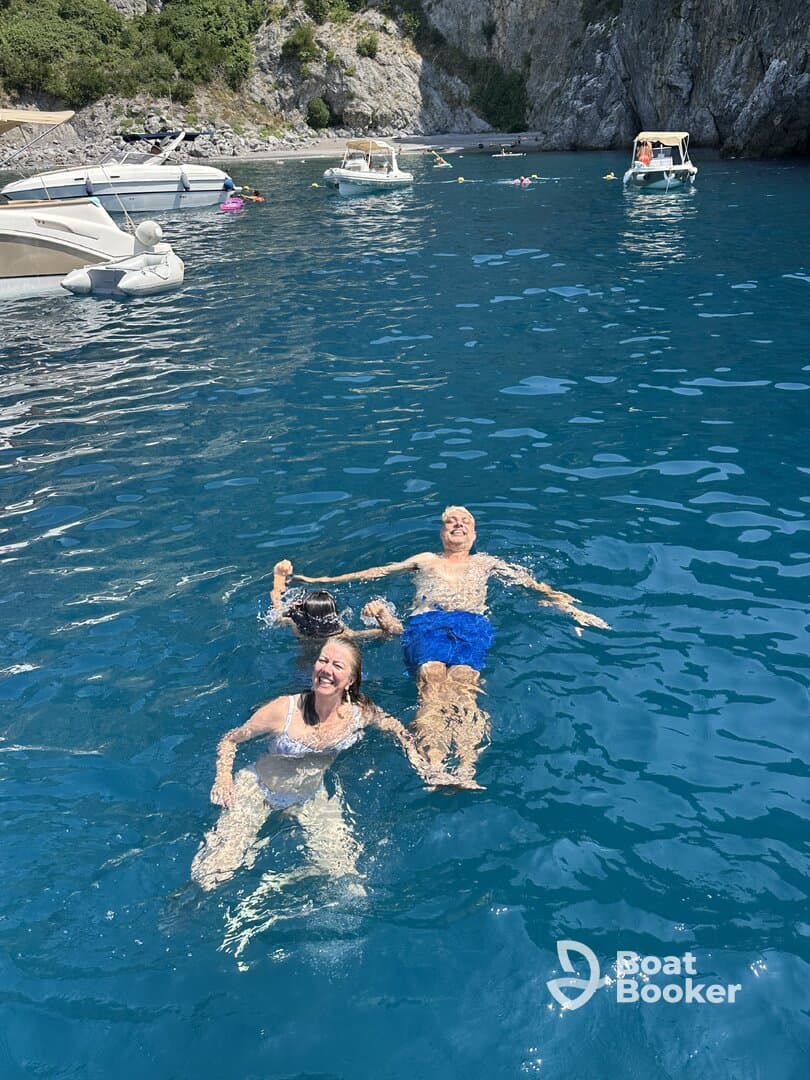 A joyful family enjoys swimming in crystal-clear waters, creating unforgettable memories on their boating adventure.
