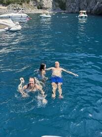 A joyful family enjoys a refreshing swim in crystal-clear waters, creating unforgettable memories on their boating adventure.
