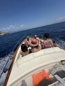 A lively group enjoys a sunny day on a boat, sharing drinks and laughter — perfect for summer outings and celebrations on the water.