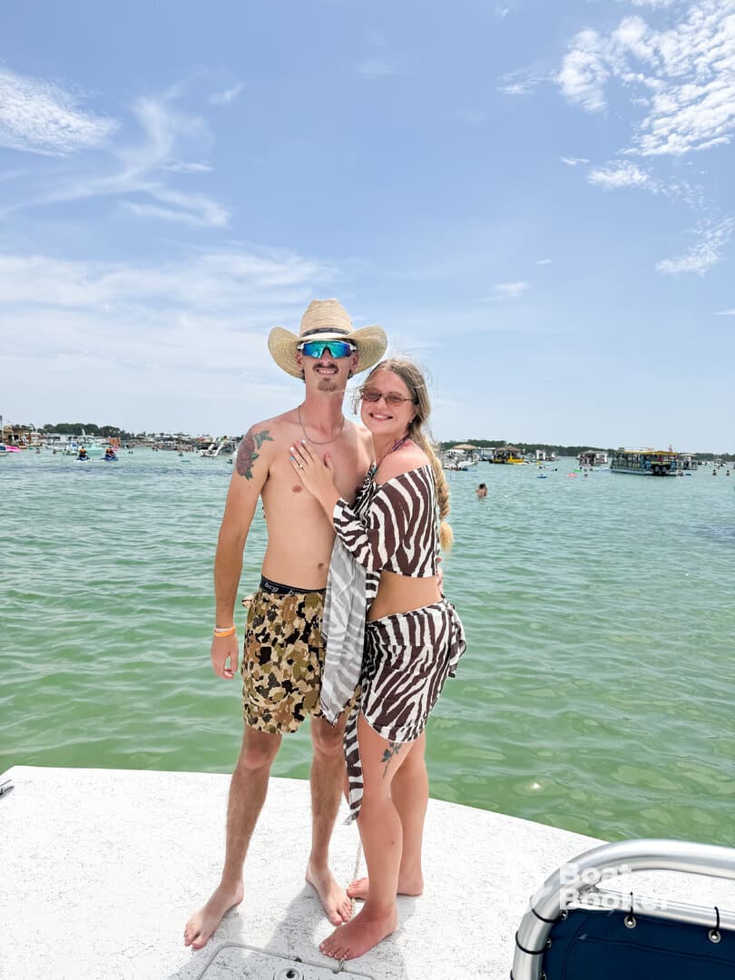A happy couple poses together on the deck of a boat, enjoying a sunny day on the water — perfect for summer adventures and romantic getaways.