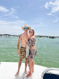 A happy couple poses together on the deck of a boat, enjoying a sunny day on the water — perfect for summer adventures and romantic getaways.