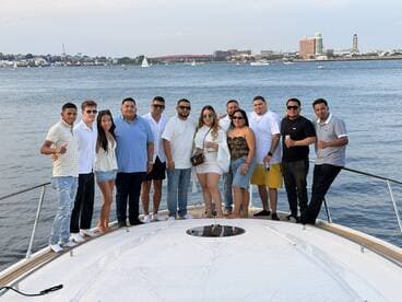 A lively group poses for a photo on the deck of a boat, enjoying a fun day on the water — perfect for celebrations and gatherings with friends.