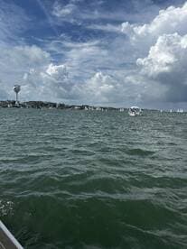 A scenic view of a busy waterway with sailboats in the distance, showcasing the vibrant atmosphere of a sailing destination.