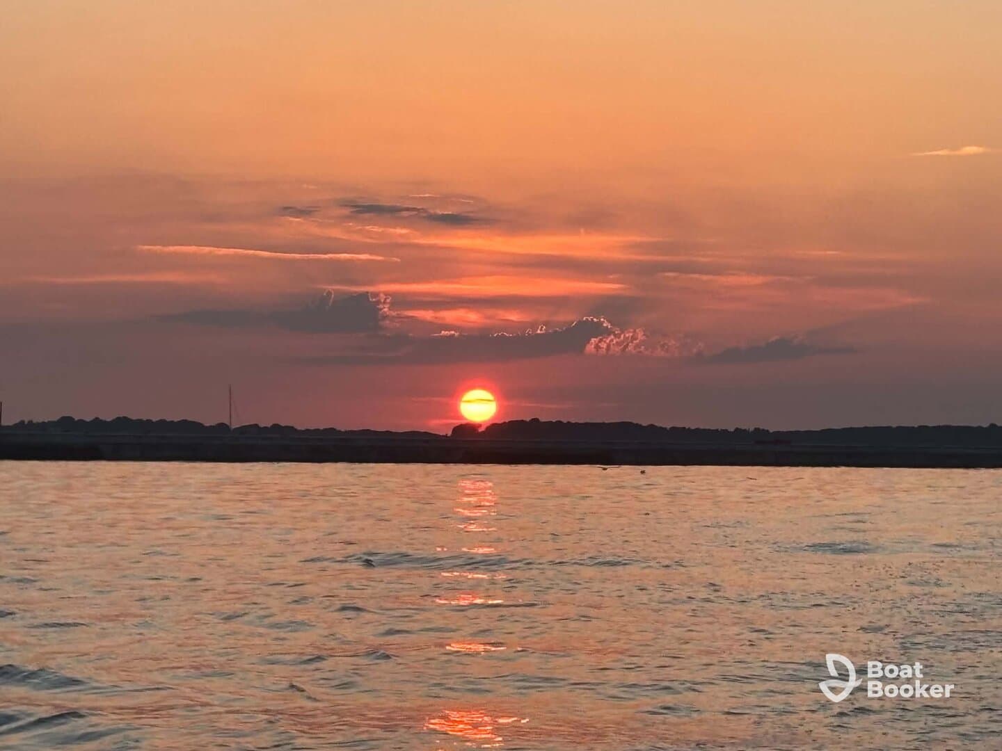 A stunning sunset over calm waters, creating a picturesque backdrop for evening boat outings.