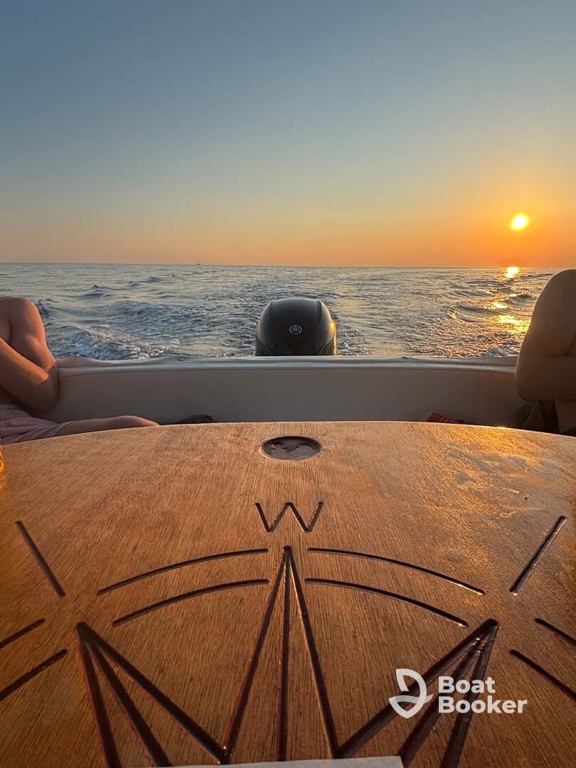 A serene sunset view from a boat, showcasing the calm ocean and relaxed passengers enjoying the tranquil atmosphere.