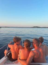 A family enjoys a serene sunset view from their boat, creating lasting memories on the water. Perfect for family outings and relaxation.