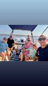 A joyful family enjoys a sunny day on a boat, capturing fun moments together — perfect for creating lasting memories on the water.