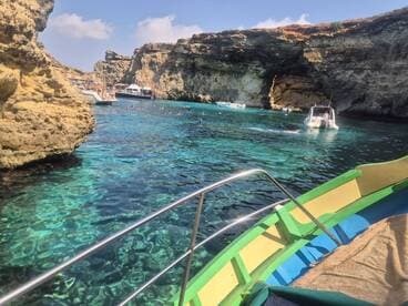 A vibrant scene of swimmers enjoying the crystal-clear waters of a picturesque cove, with multiple boats anchored nearby — perfect for a day of fun and exploration.
