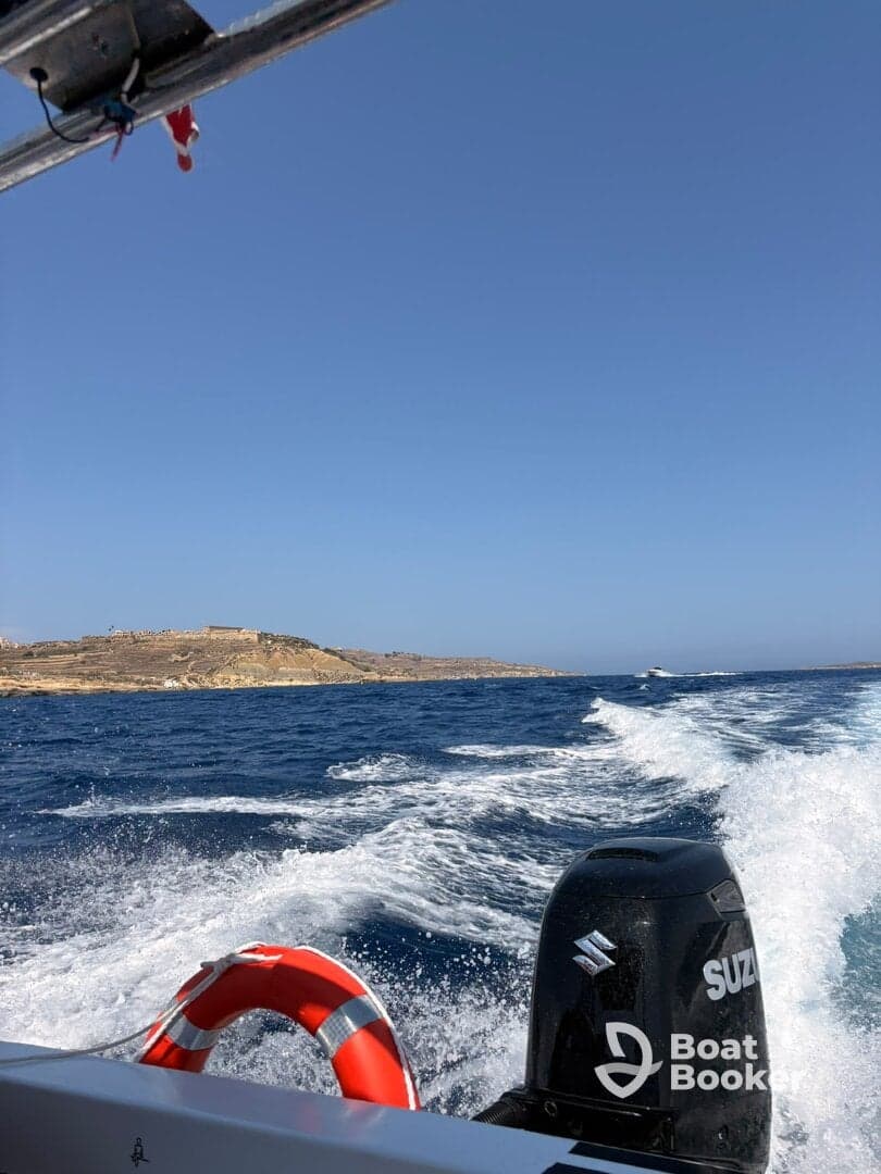 A scenic view from a boat cruising through vibrant blue waters, showcasing the coastline and creating a perfect backdrop for a day of adventure on the sea.