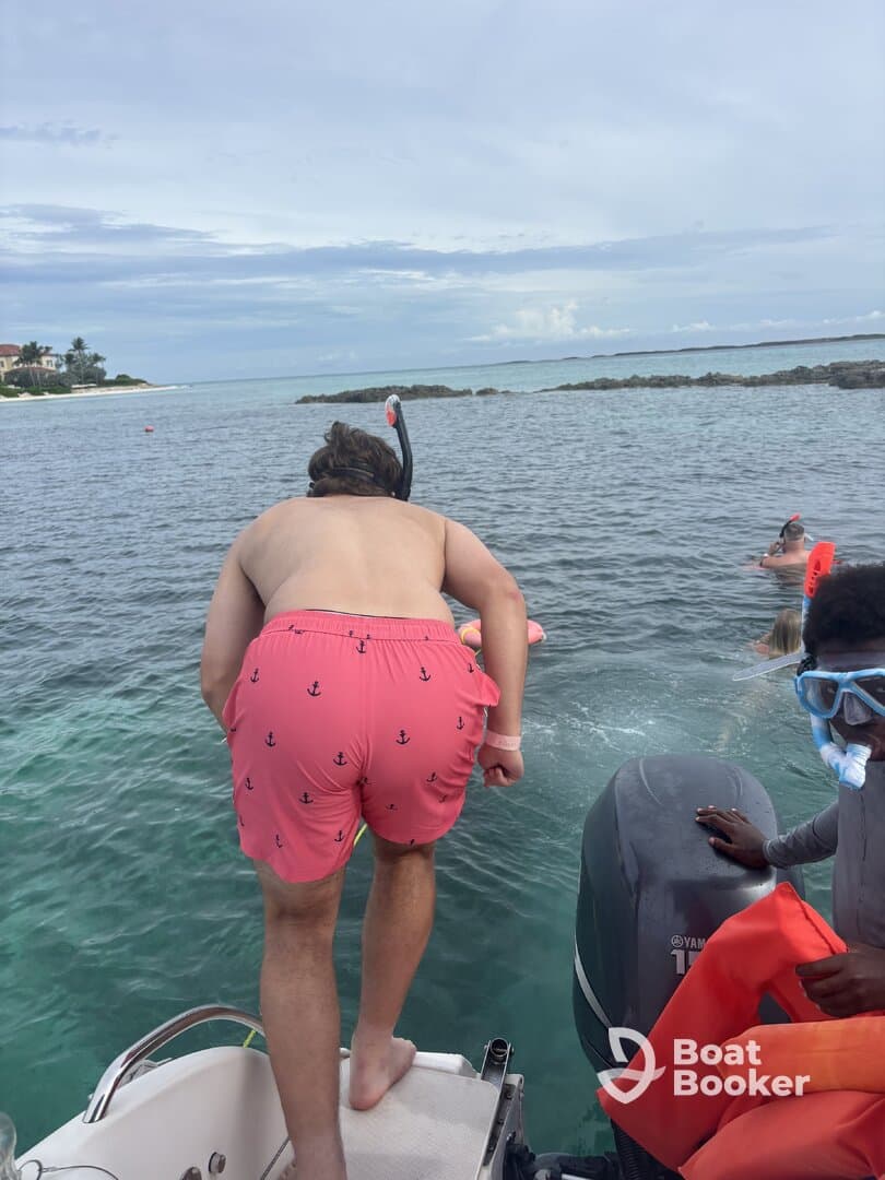 A group of friends prepares to snorkel in crystal-clear waters, showcasing the excitement of water activities and adventure on a boat trip.