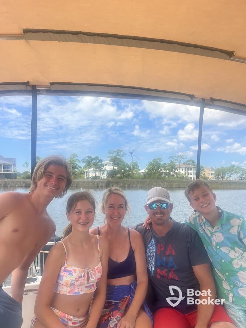 A cheerful family poses together on a boat, enjoying their time on the water — perfect for creating lasting memories during summer outings.