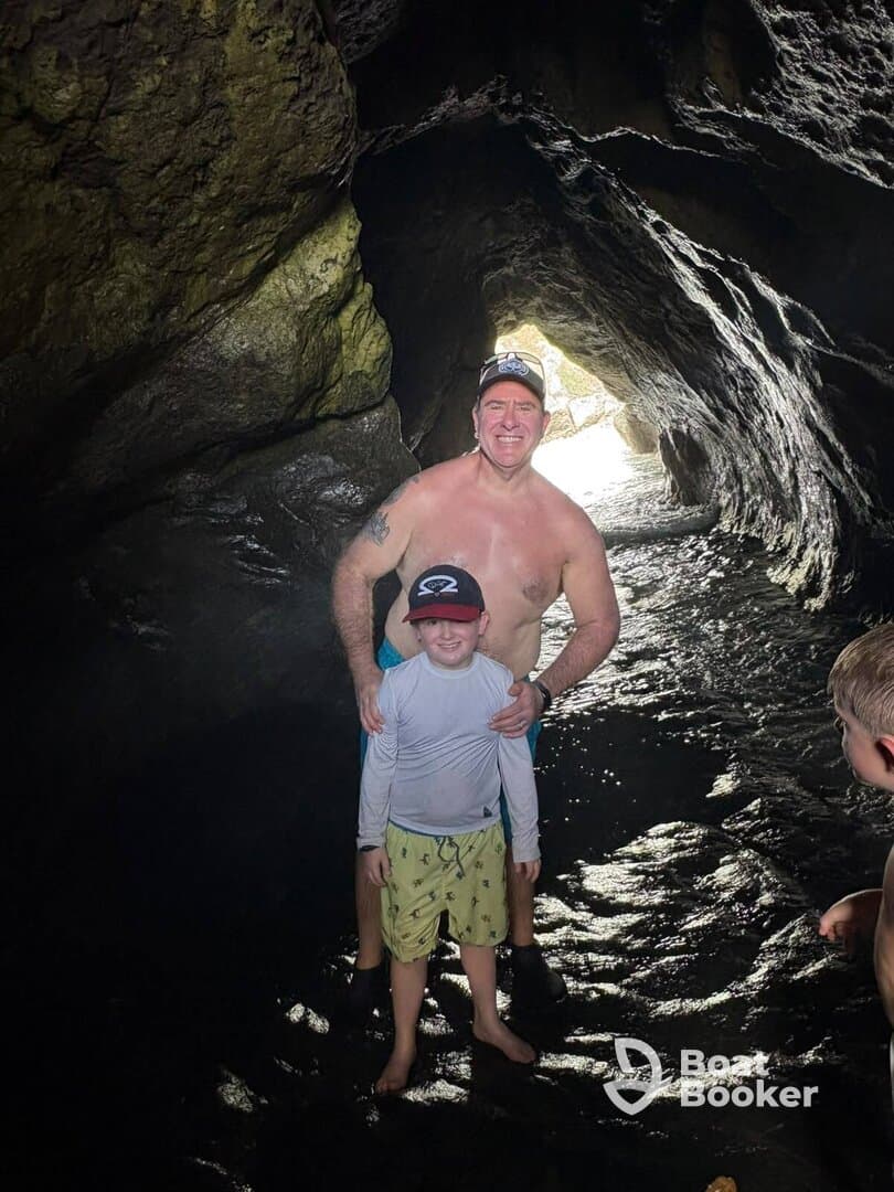 A joyful moment captured inside a cave, showcasing a family enjoying their swimming adventure — perfect for exploring hidden gems on a boat trip.