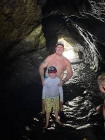 A joyful moment captured inside a cave, showcasing a family enjoying their swimming adventure — perfect for exploring hidden gems on a boat trip.