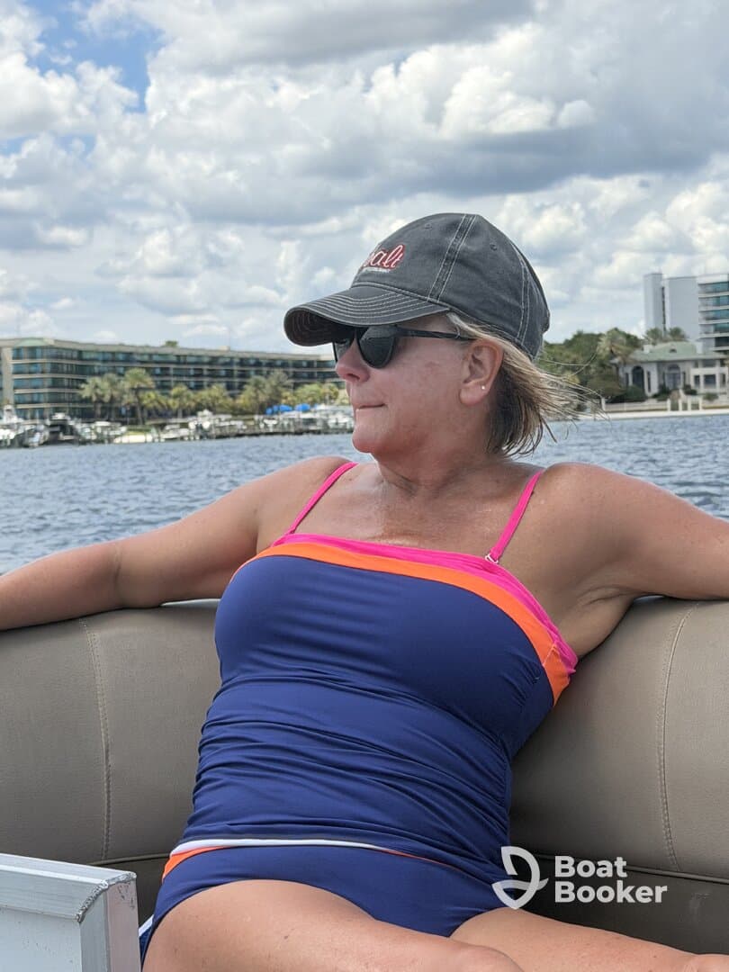 A woman enjoys a relaxing moment on a boat, soaking in the sun and the beautiful water views — perfect for a day out on the water.