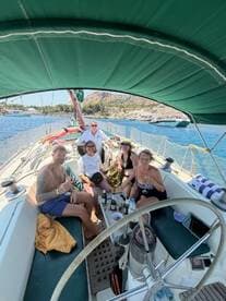 A lively group enjoys drinks and camaraderie aboard a sailboat, capturing the essence of a perfect day on the water.