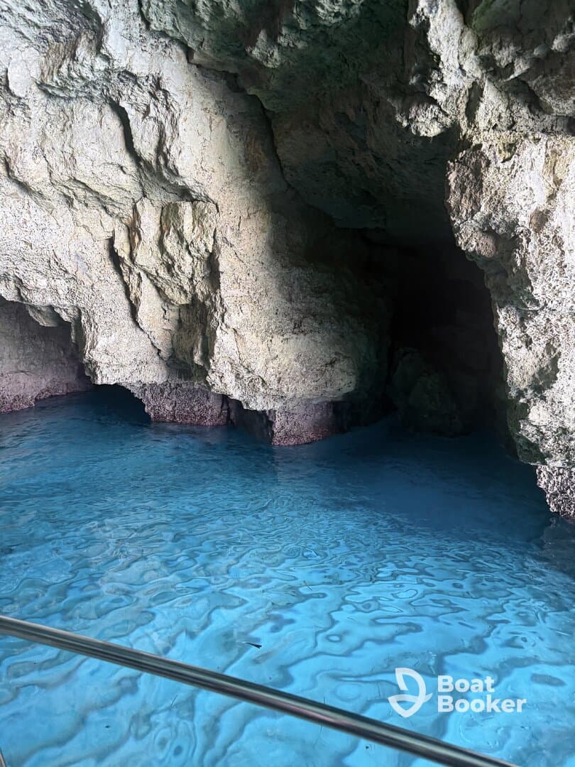A stunning view of a cave with vibrant blue water, showcasing the natural beauty of the surroundings — perfect for eco tours and exploration.