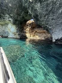 A stunning view of a natural rock arch over crystal-clear turquoise waters, showcasing the breathtaking coastline and inviting exploration.