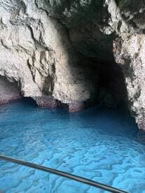 A stunning view of a cave with vibrant blue water, showcasing the natural beauty of the surroundings — perfect for eco tours and exploration.