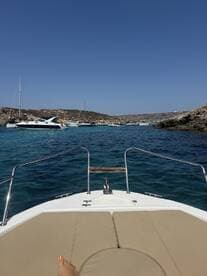 A view from the front of a boat showcasing the stunning turquoise waters and anchored vessels, perfect for a day of relaxation and exploration on the water.