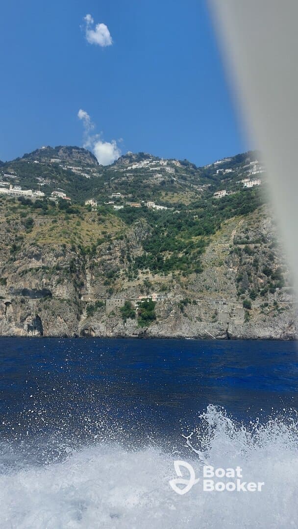 A stunning view of the Amalfi Coast from a boat, showcasing the dramatic cliffs and charming villages along the shoreline, perfect for scenic boat tours.