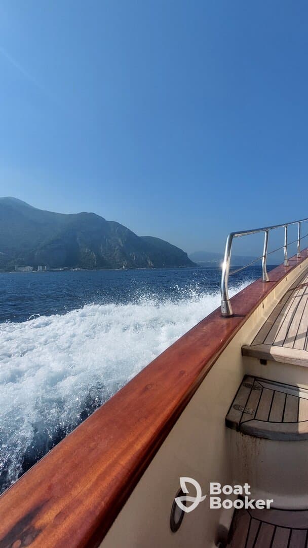 A scenic view of a boat in motion, showcasing the beautiful coastline and clear blue skies — perfect for adventure seekers and nature lovers.