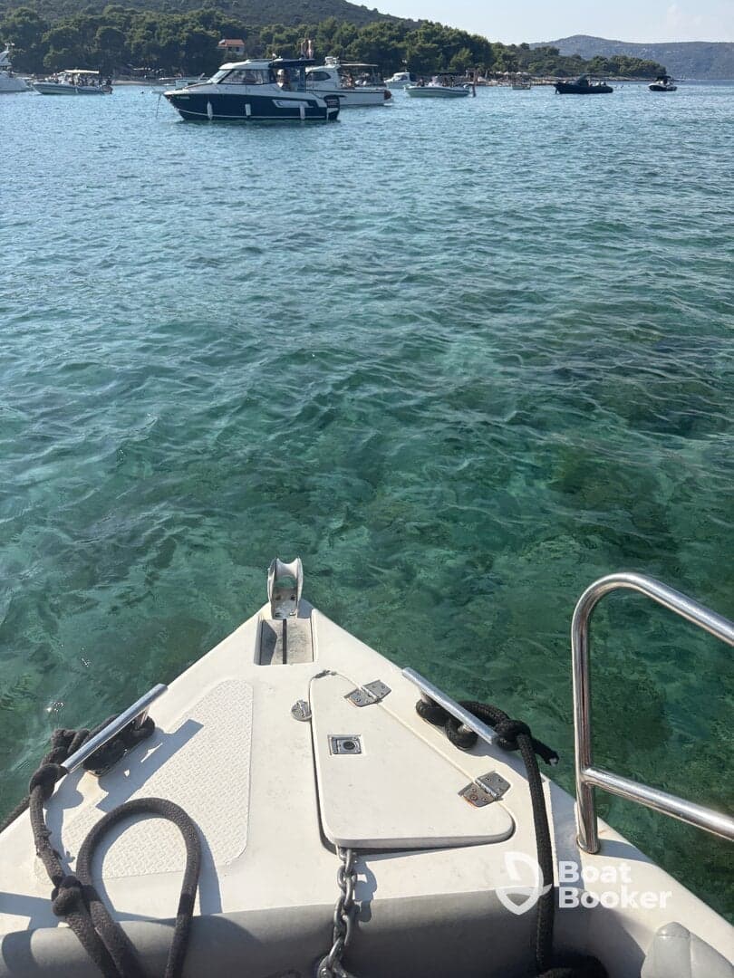 A clear view from the bow of a boat, showcasing the tranquil turquoise waters and surrounding vessels, perfect for a day of exploration on the water.