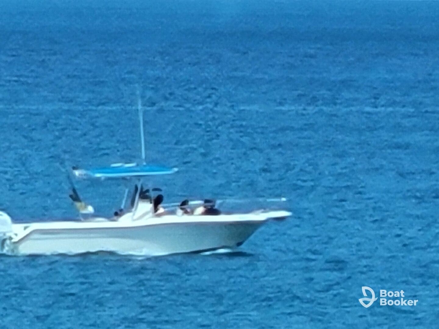 A speedboat glides through the vibrant blue waters, showcasing a lively group onboard enjoying their time on the water.