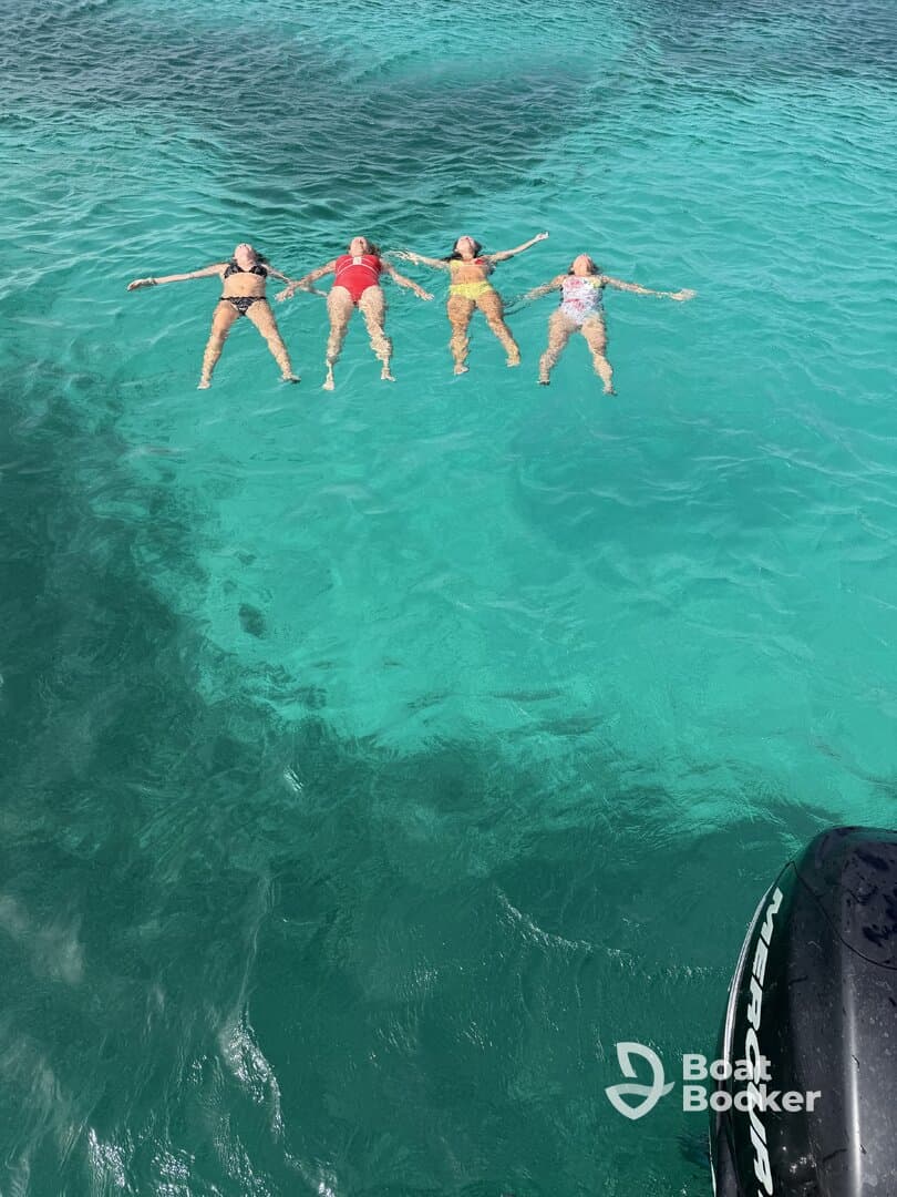 A group of friends floats together in the stunning turquoise waters, enjoying a perfect day of relaxation and fun under the sun.