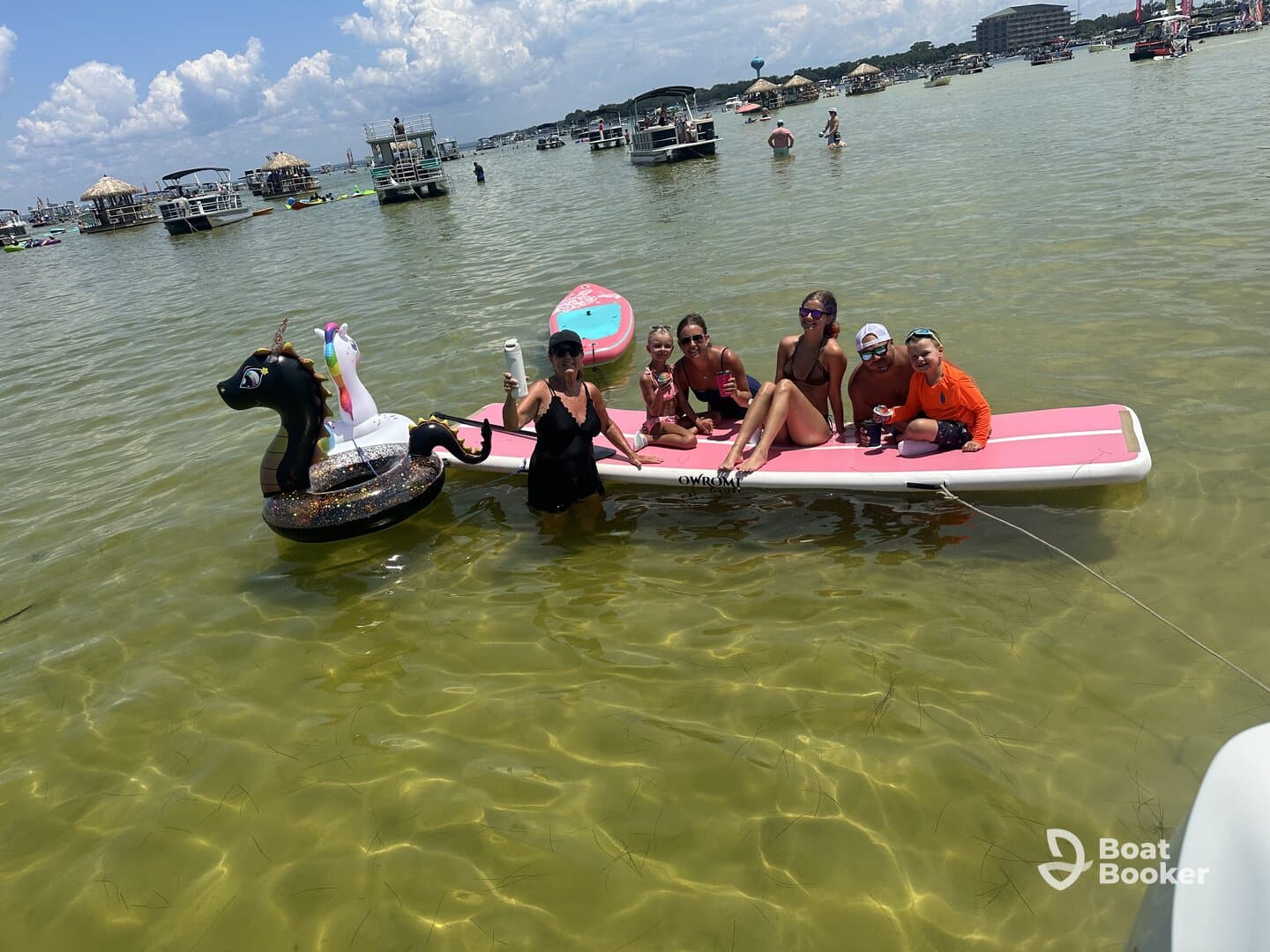 A lively group enjoys a fun day on the water with inflatable toys, showcasing family bonding and summer activities in a vibrant setting.