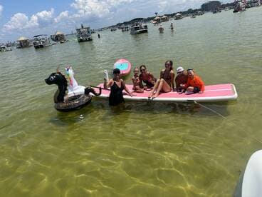 A lively group enjoys a fun day on the water with inflatable toys, showcasing family bonding and summer activities in a vibrant setting.