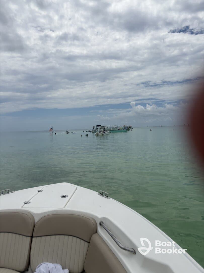 A scenic view from the bow of a boat, showcasing a nearby anchored vessel in calm waters — perfect for a day of relaxation and exploration on the water.