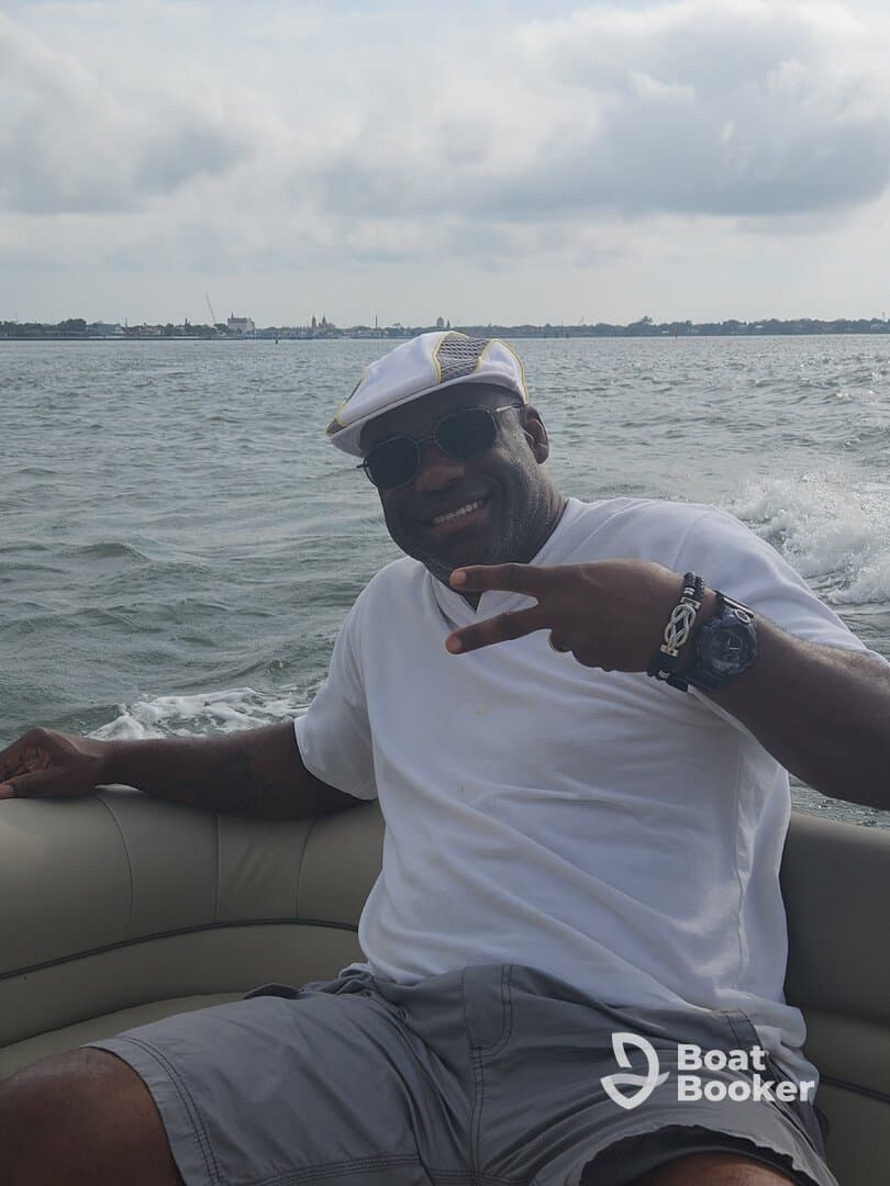 A joyful individual poses with a peace sign while enjoying a day on the water, capturing the essence of fun and relaxation during a boating adventure.