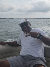 A joyful individual poses with a peace sign while enjoying a day on the water, capturing the essence of fun and relaxation during a boating adventure.